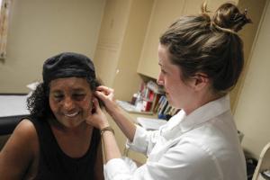 Pacific School of Oriental Medicine student Casey Culp works with Azeba Ghebrewold after treating her with acupuncture during The Pacific Beach Free Clinic, put on by the Pacific School of Oriental Medicine, at the Pacific Beach United Methodist Church in Pacific Beach on Wednesday. Hayne Palmour IV/San Diego Union-Tribune