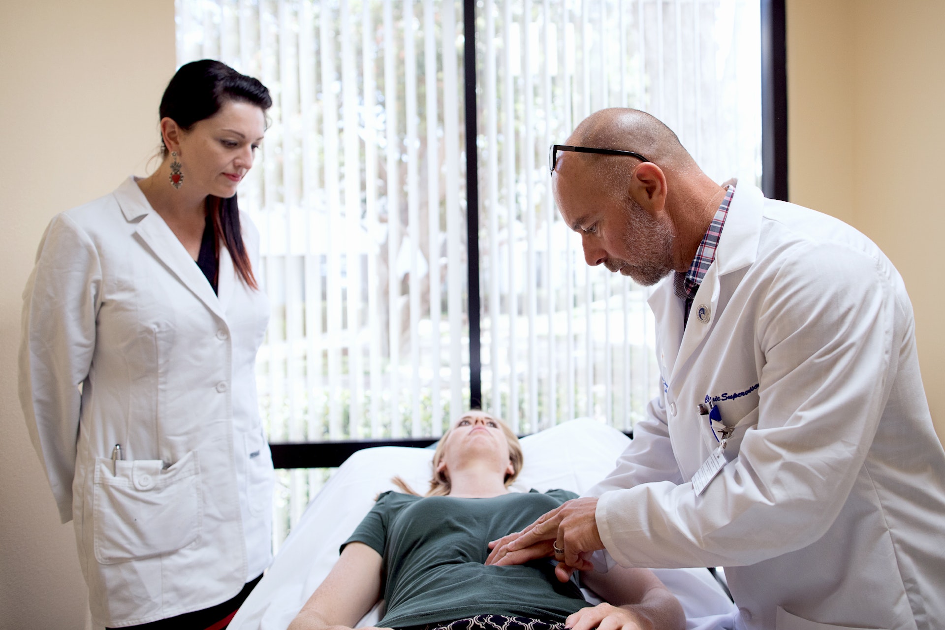 Acupuncture student observing practitioner demonstrating treatment during clinical training