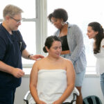 Acupuncture student practicing needle technique under instructor supervision in a clinical training setting