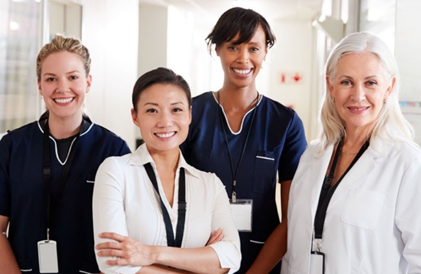 Group of nurses and healthcare professionals smiling together in a clinical setting